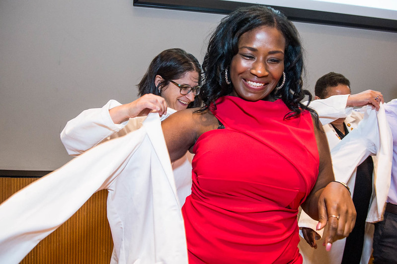 A student receives their white coat during the Class of 2023 White Coat ceremony