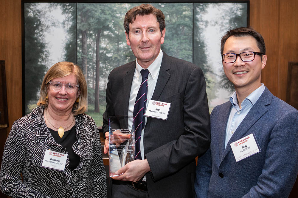Dr. John MacMicking (center) accepts his award from Dr. Barbara Hempstead and Dr. Ting Jia