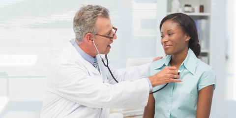 Doctor checking patient's heartbeat.
