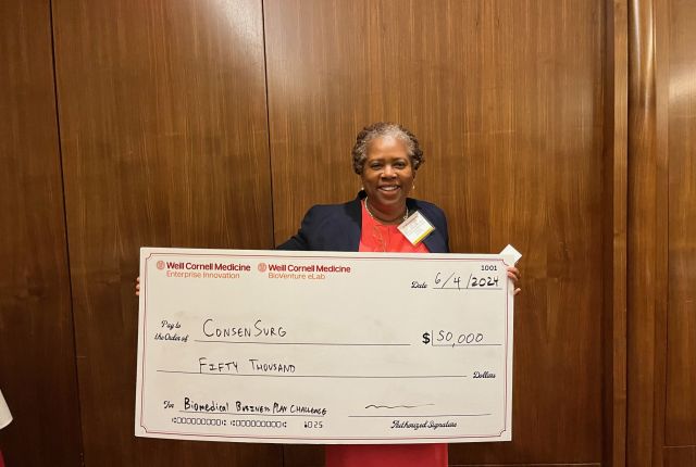 Dr. Denise Howard holding a big check of $50,000.