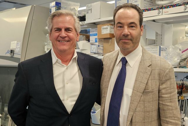 Two Caucasian men wearing suits standing in a lab