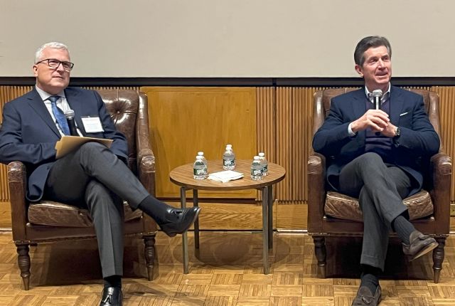Two Caucasian men in business attire sitting on sofas